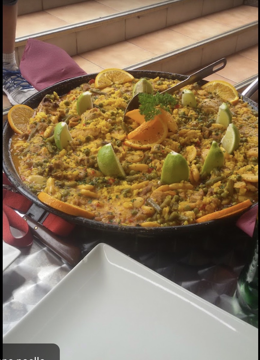 Paella mixta en paellera con limón y naranja