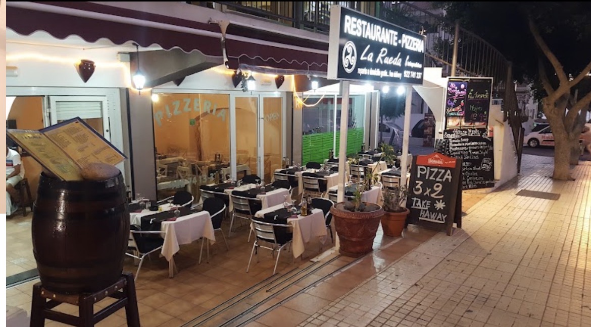 Fachada iluminada del Restaurante Pizzería Mums Pizza por la noche